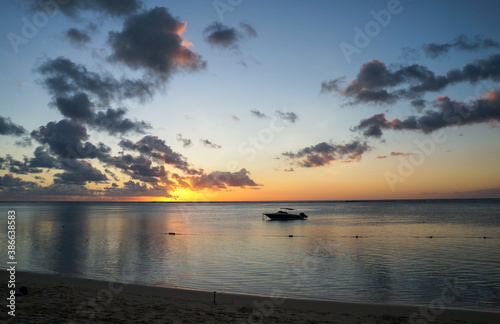 tramonto sul mare, barca ormeggiata, mare piatto, nuvole e riflessi. mauritius 
