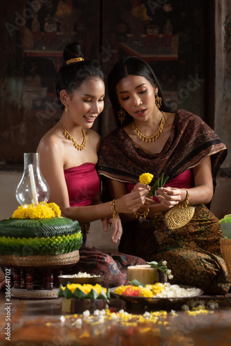 Two thai woman in traditional dress costume making and decorating Krathong. Loy Krathong Festival. photo