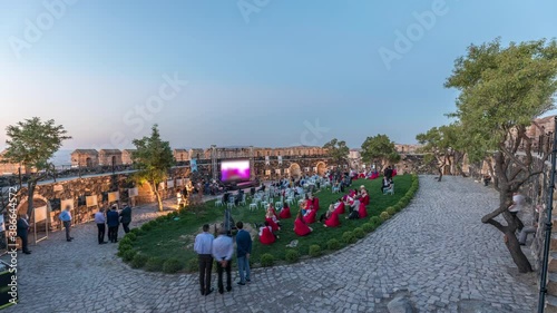 People are enjoying the open air cinema in the hictoric building at evening aerial timelapse after sunset. Chairs with social distancing during pandemic situation photo