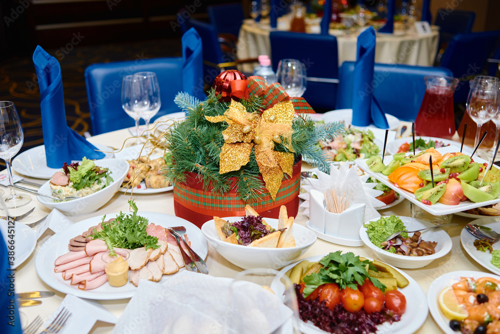 Table setting with white plates , blue serviettes and cutlery on table, copy space. Place setting at Christmas party. Table served for New year banquet in restaurant Table setting with white plates , blue serviettes and cutlery on table, copy space. Place setting at Christmas party. Table served for New year banquet in restaurant