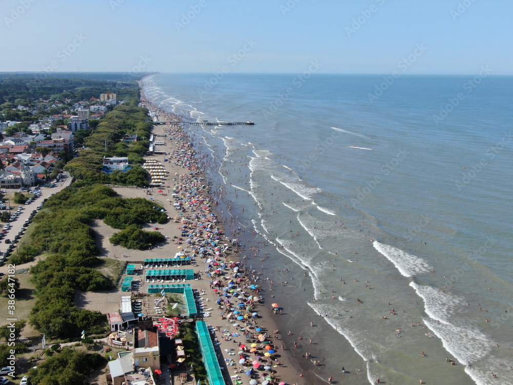 Vista desde un dron, de la costa del mar y los pueblos frente a la costa, durante la temporada de vacaciones en un día de sol.