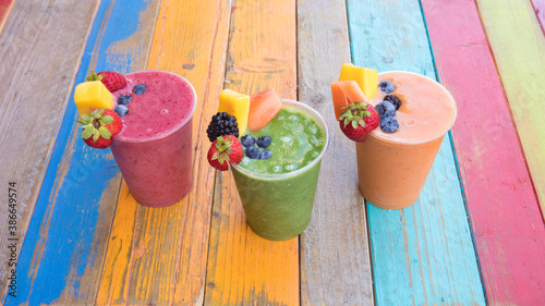 Colorful, tasty and healthy fruit smoothies on a colorful wood table © Melanie