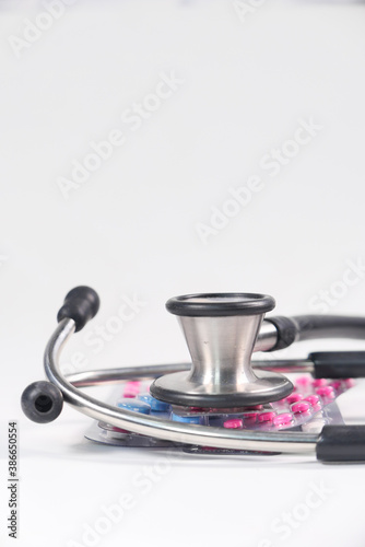 blister pack and stethoscope on white background 