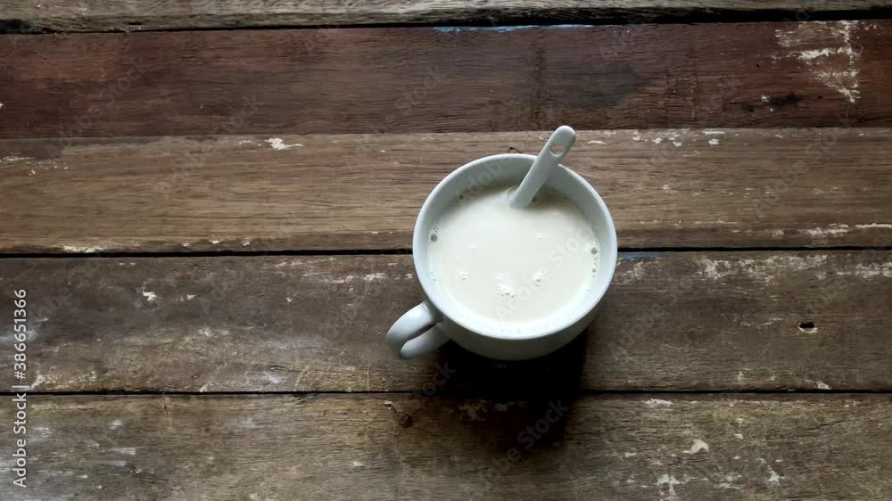 Soy milk or milk in mug on old wood table top,natural dimly light,selective focus.Healthy Breakfast in morning. Soy milk or milk in mug on old wood table top,natural dimly light,selective focus.Healthy Breakfast in morning.