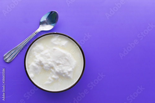 close up of fresh yogurt in a bowl on color background 