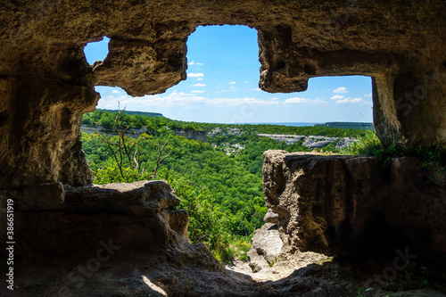 Cross-like window inside artificial caves of ancient city Chufut-Kale  Bakhchisaray  Crimea. Caves were used for different goals  living  storing  religious etc 