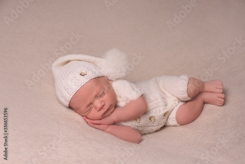 Cute infant Newborn baby in a  knitted hat on a blanket. Portrait of newborn baby. Face of sleeping small child
