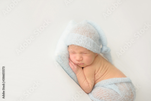 Cute infant Newborn baby in a  knitted hat on a blanket. Portrait of newborn baby. Face of sleeping small child
