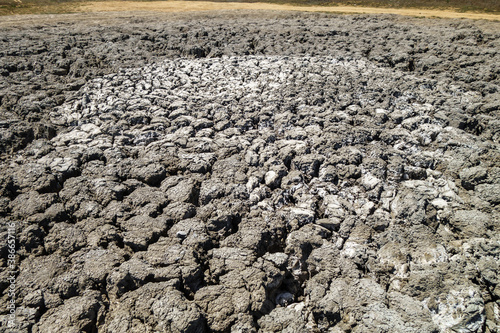 Center of crater of big mud volcano (light grey color). It 'sleeps' after series of eruptions. Remains of mud dried & cracked under sunlight. Depth of cracks about 6-8 inches. Shot near Kerch, Crimea
