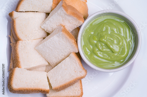 Thai Bread pandan custard of dessert , Slice steamed bread and pandan custard on wooden