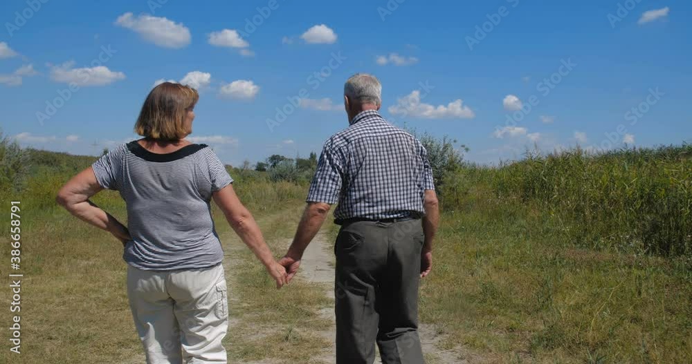 Active happy and healthy elderly European couple on a walk with their two granddaughters enjoying beautiful landscape. Tracking shot, rear view. slow motion 4k 50 fps Active happy and healthy elderly European couple on a walk with their two granddaughters enjoying beautiful landscape. Tracking shot, rear view. slow motion 4k 50 fps