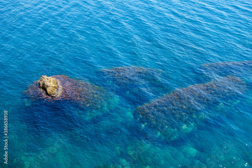 Top view of the sea surface. Underwater reefs are visible, part of one of them comes out