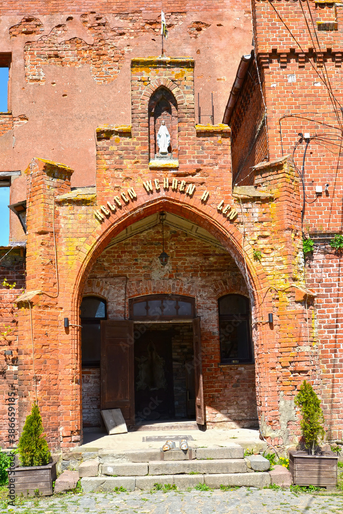 Arched portal in Shaaken Castle, XIII century. Kalinnigrad region. German text - help fight