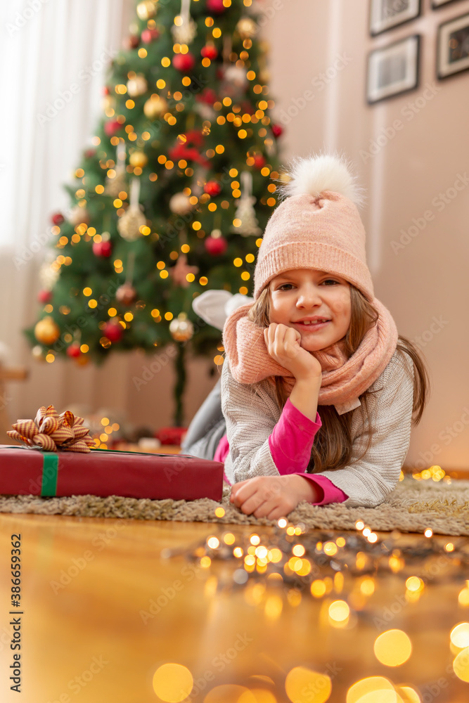 Little girl lying next to Christmas tree Little girl lying next to Christmas tree