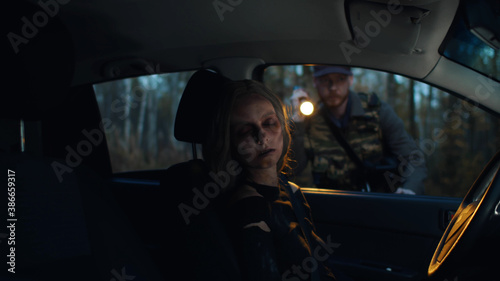 Young man with flashlight finding car in forest with infected woman driver © TommyStockProject