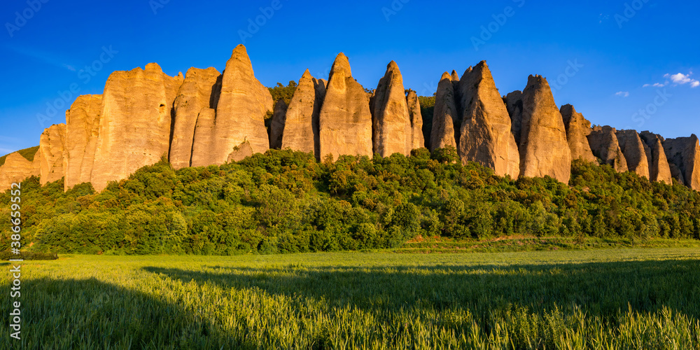 Sunset on monolith rock formation called "Les Pénitents" near the village of Les Mées. The geologic formation was named for resemblance to monks. Alpes-de-Haute-Provence, PACA Region, France - obrazy, fototapety, plakaty 