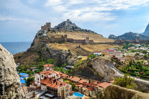 Panorama of city Sudak from hill Sugar Head, Crimea. There are famous Genoese fortress, residential houses & Black Sea. photo