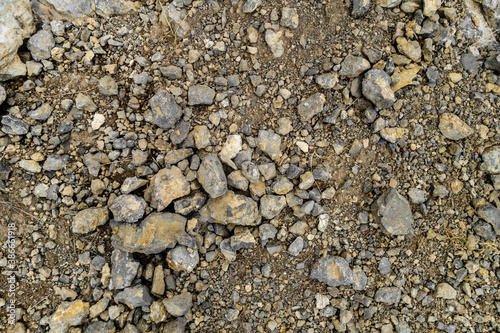 View from above onto surface of ground in mountains covered by stones & pieces of rocks