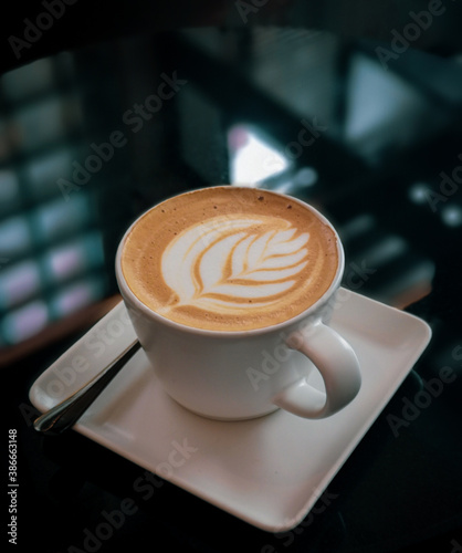beautiful cup of latte art for coffee break on black table inside the cafe