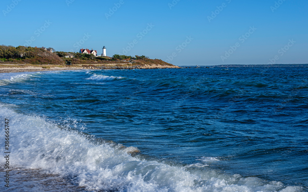 Blue Ocean Seascape with long white foamy waves washing up on the beach near Nobska Lighthouse in Woods Hole on Cape Cod Blue Ocean Seascape with long white foamy waves washing up on the beach near Nobska Lighthouse in Woods Hole on Cape Cod
