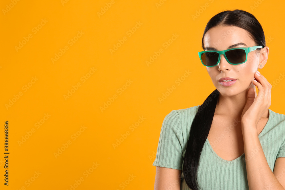 Beautiful woman wearing sunglasses on yellow background. Space for text Beautiful woman wearing sunglasses on yellow background. Space for text