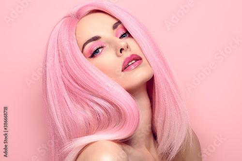 Beauty Fashion woman with Colorful Pink Dyed Hair. Girl with blue eyes, perfect Makeup and Hairstyle. Beautiful smiling model portrait, fashionable pink make up, hair. Skincare concept