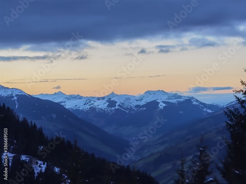 beautiful sunset on the mountains with orange sky and fresh snow on the mountains in autumn