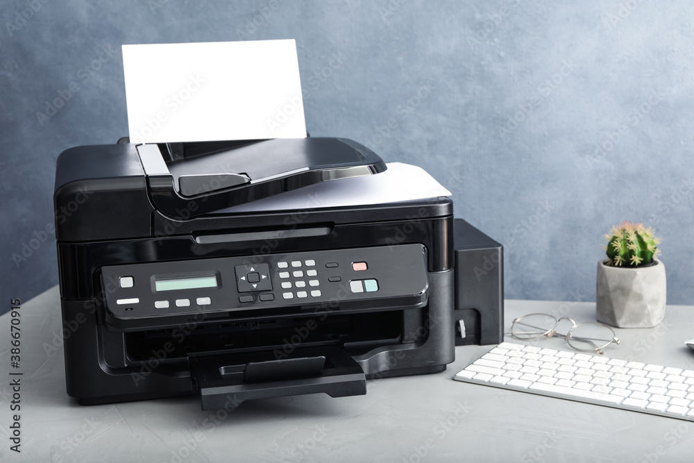 Modern printer with paper and computer keyboard on grey table Modern printer with paper and computer keyboard on grey table