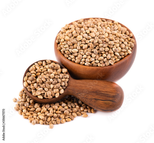 Hemp seeds isolated on white background. Dry seeds of cannabis, hemp or marijuana in wooden bowl and spoon.