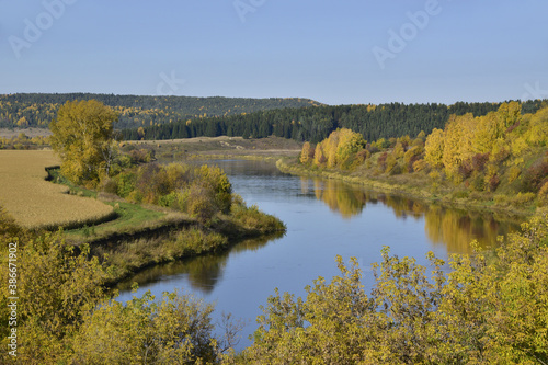 Ural river Sylva among fields and forests in autumn decoration. In the foothills of the Western Urals, golden autumn.
