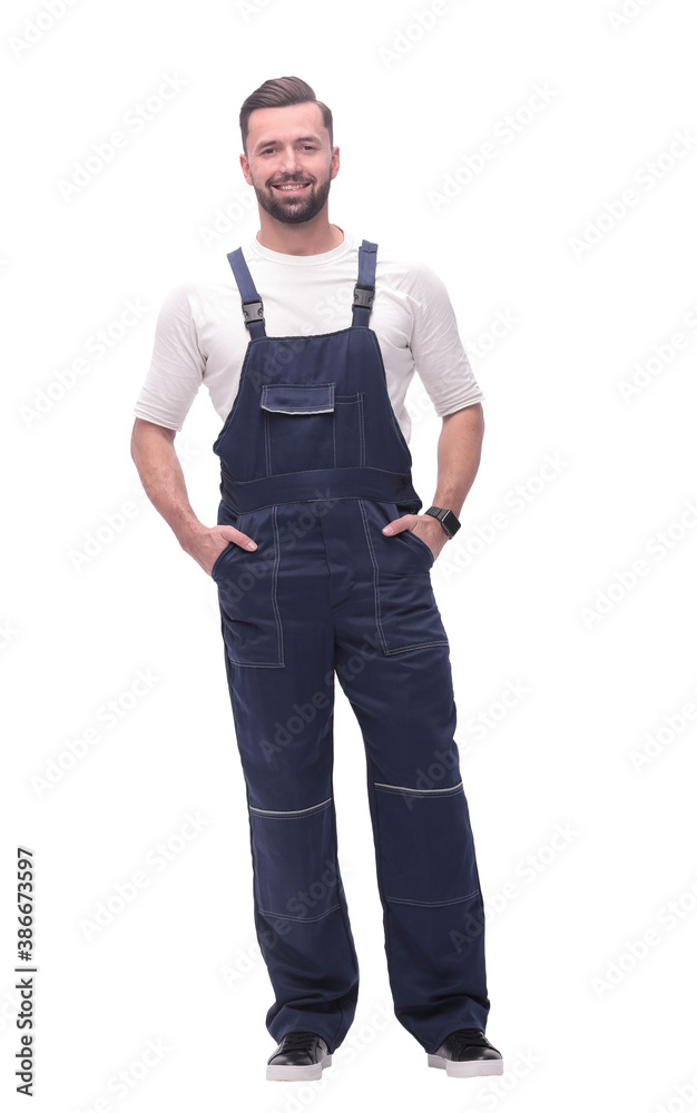 in full growth. smiling man in overalls. in full growth. smiling man in overalls.