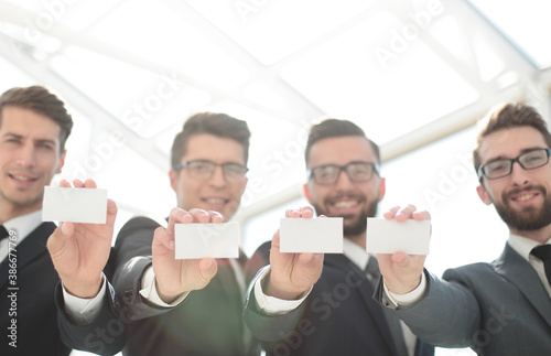 four young business people showing their business card