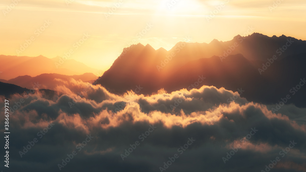 Aitzgorri mountain silhouette with sea of clouds and sun rays Aitzgorri mountain silhouette with sea of clouds and sun rays