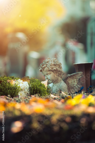 Remembrance concept: White angel on a grave, flowers photo