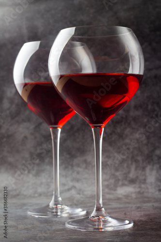 two glasses on a long stem with red wine.
