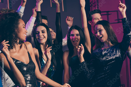 Photo of girls company dancing in night club with neon lights celebrating new year together chilling relaxing wearing fashionable dresses