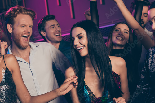 Portrait photo of cheerful girl dancing on dance floor in night club laughing celebrating together xmas on party with friends