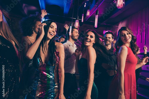Photo portrait of happy men and women dancing together at nightclub throwing hair in the air