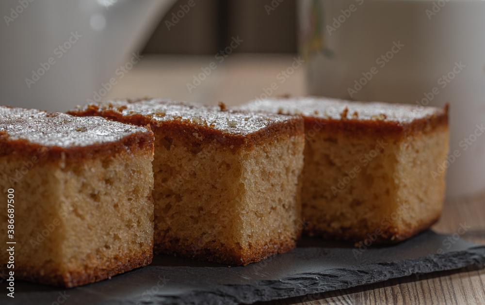 Three pieces of cake and a cup of tea over a wooden table Three pieces of cake and a cup of tea over a wooden table
