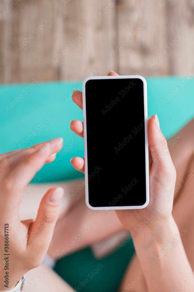 Selective focus of woman with cellphone with blank screen