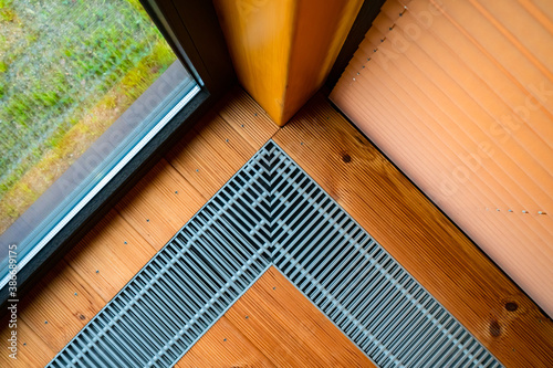 Heating in the floor of the cottage. Ventilation grilles in the floor. Maintaining a favorable microclimate in the room. Heating and ventilation systems.