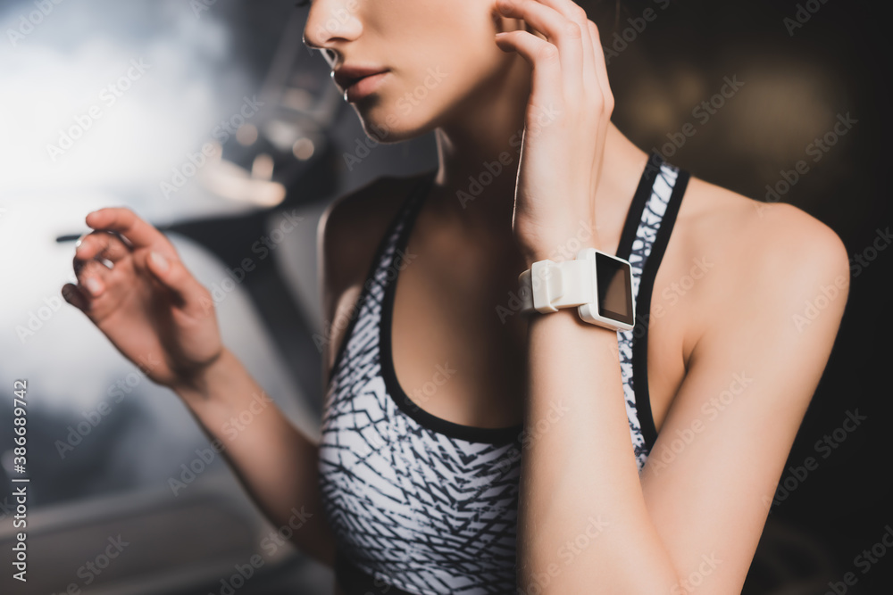 Cropped view of sportswoman with smartwatch in gym