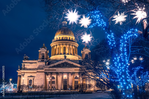 Christmas Saint Petersburg. New year card from Russia. St. Isaac Cathedral on the background of garlands and glowing stars. Festive evening in Russia. Merry Christmas from Russia.