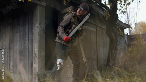 Fotografia Man with wounded leg leaving shed surviving in post apocalypse world
