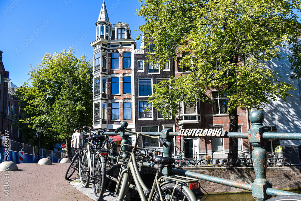 Bicycles on the'Sleutel' Bridge against a setting of historic facades in Amsterdam, the Netherlands.