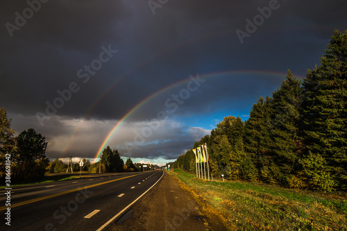beautiful double rainbow stands over the road