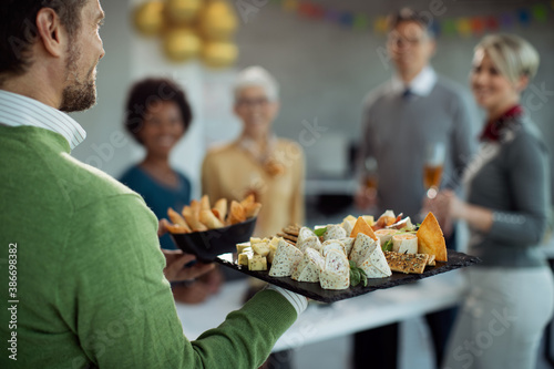 Close-up of businessman serving food during office party.