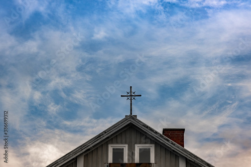 Religious cross on top of a building looking up in the sky
