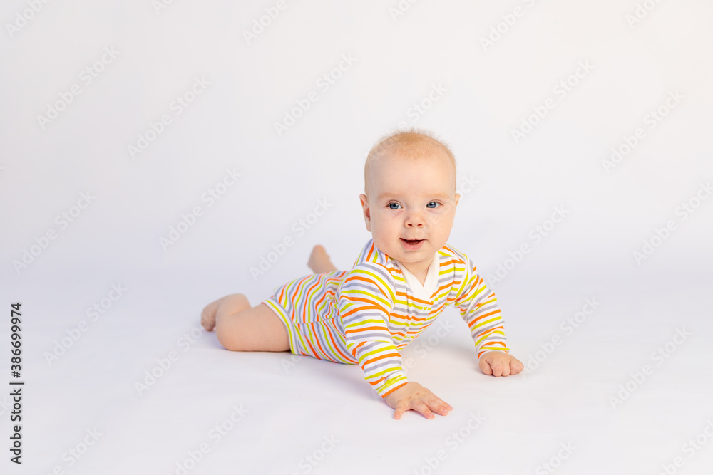 small smiling baby girl 6 months old lies on a white isolated background in a bright bodysuit, space for text. A healthy happy child. small smiling baby girl 6 months old lies on a white isolated background in a bright bodysuit, space for text. A healthy happy child.