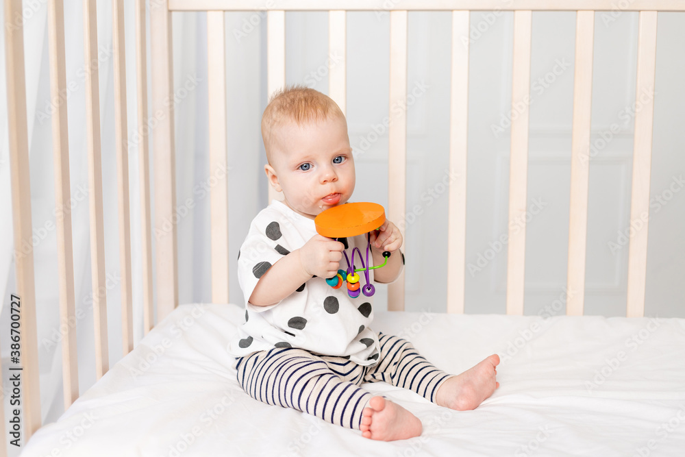 baby 8 months playing in the crib, early development of children up to a year, a place for text